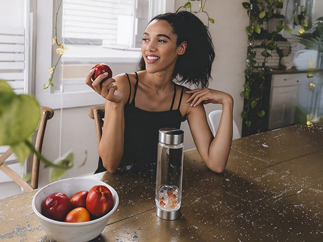 Frau mit Apfel und Edelsteinwasser