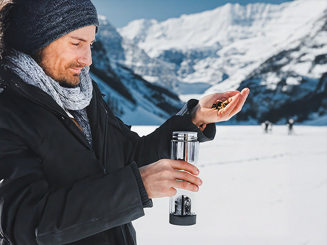 Mann in Winterkleidung mit Edelsteinwasser